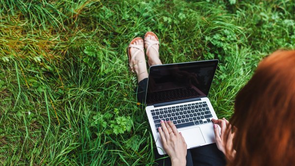 woman-sitting-grass-with-laptop Séminaire nature dans l’Eure : nos coups de cœur
